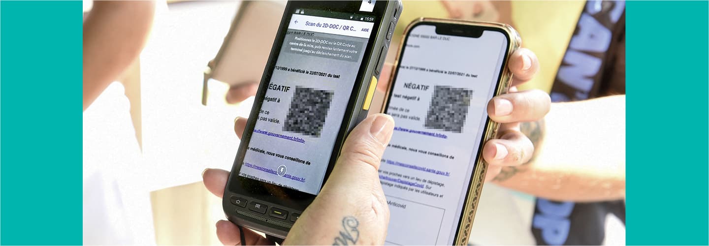 A person holding their cell phone up to a reader so it can scan the QR code on the screen