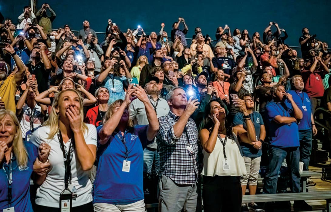 Photo of a crowd of people watching a spaceship launch