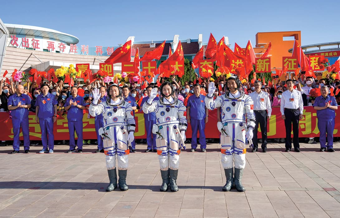 Photo of three Chinese astronauts attending a ceremony for them