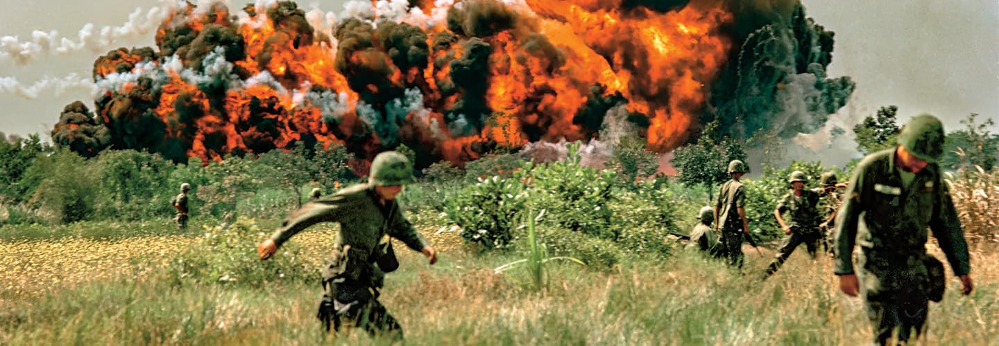 Photo of U.S. military members running from a bomb during the Vietnam War
