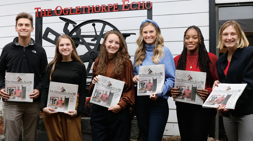 Photo of students holding a community newspaper