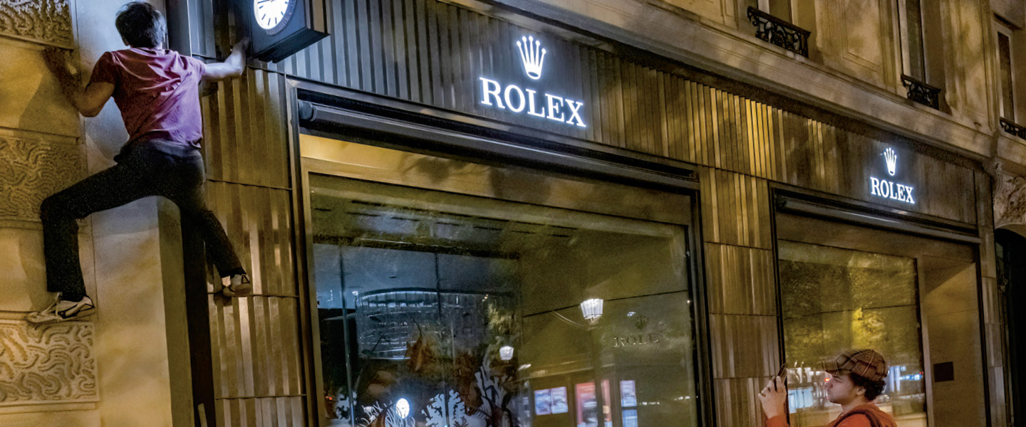 Image of a person climbing on the Rolex storefront