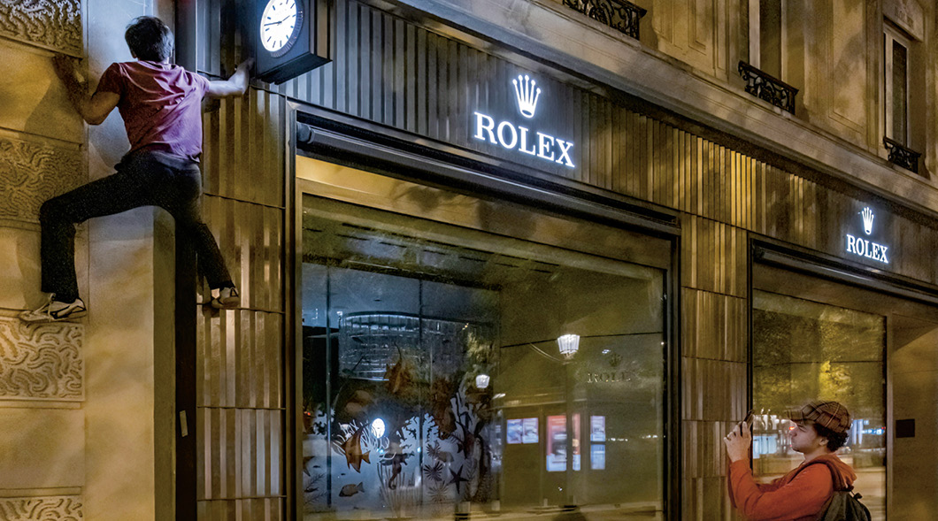 Image of a person climbing on the Rolex storefront