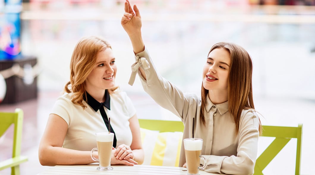 Image of two people sitting at a cafe and drinking coffee