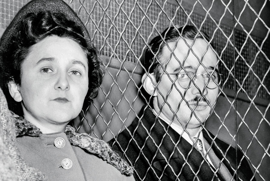 Black & white photo of Julius and Ethel Rosenberg separated by a fence