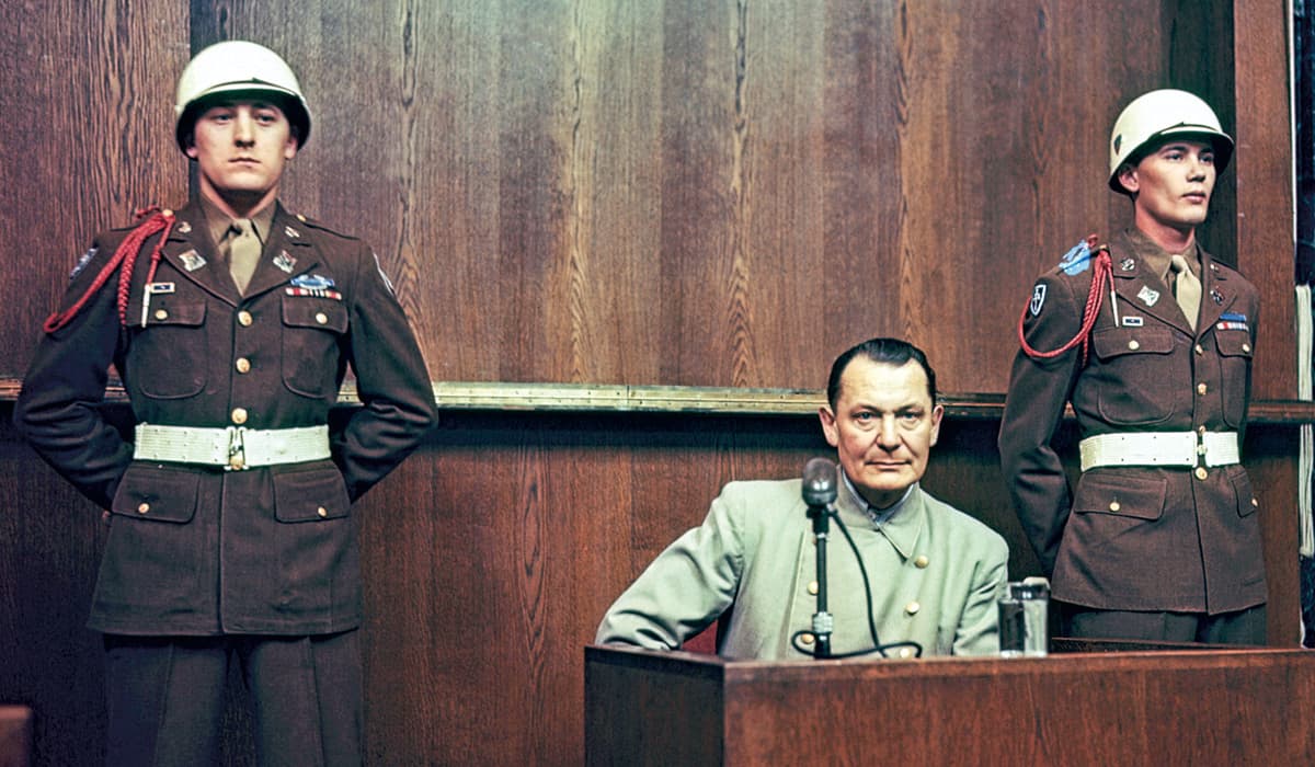 Two soldiers standing next to a person on trial