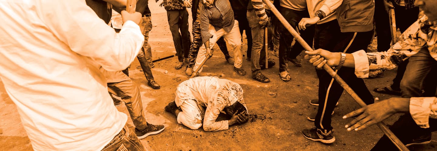 Photo of a person being beaten with sticks