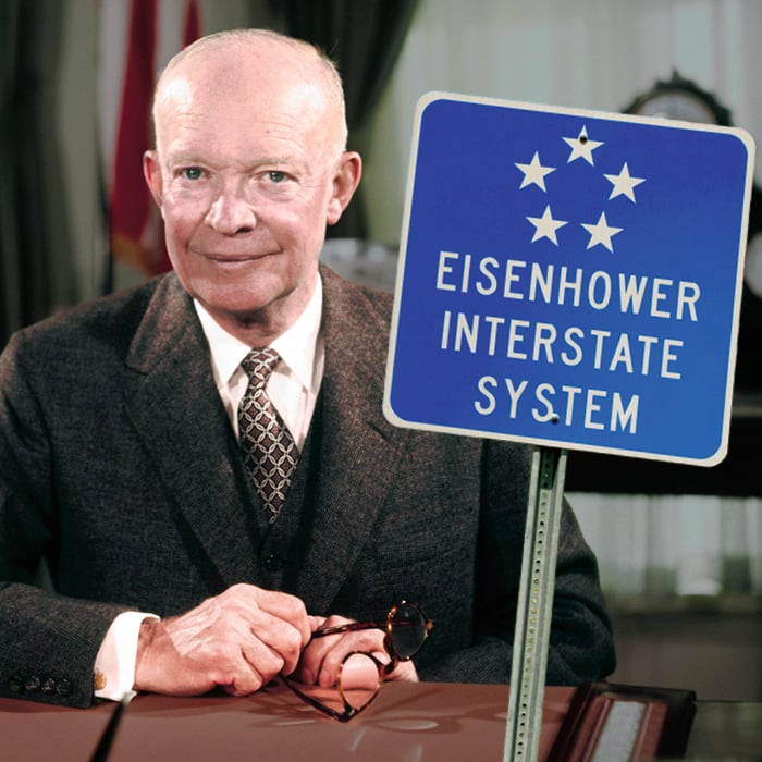 Image of Eisenhower at his desk and a sign that reads, "Eisenhower Interstate System"