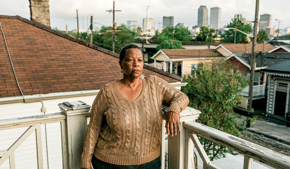 Person posing with a city in the background