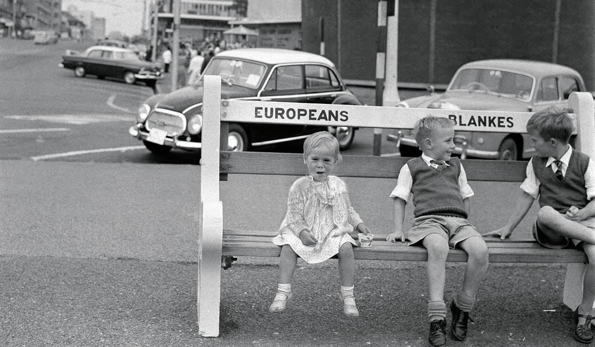 Black & white photo of a bench labeled for Europeans