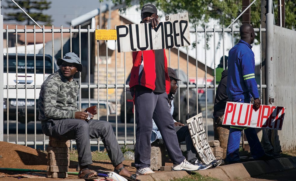 Photo of people holding up signs that say, "Plumber"