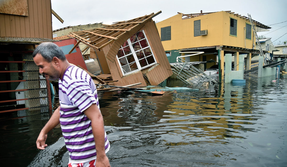 Photo of a man walking through flooded town streets in Puerto Rico