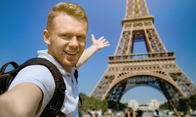 Image of a person taking a selfie in front of the Eiffel Tower