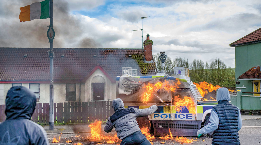 Photo of people in Ireland setting fire to a police car