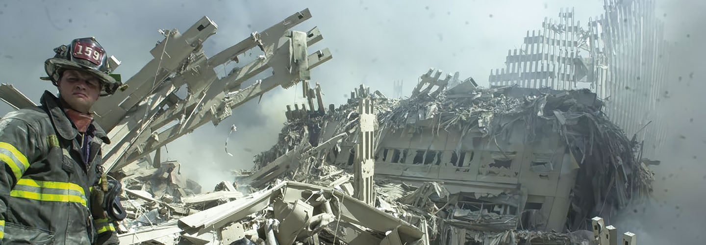 Historical photo of a firefighter near the rubble and collapsed steel of the World Trade Center on September 11, 2001