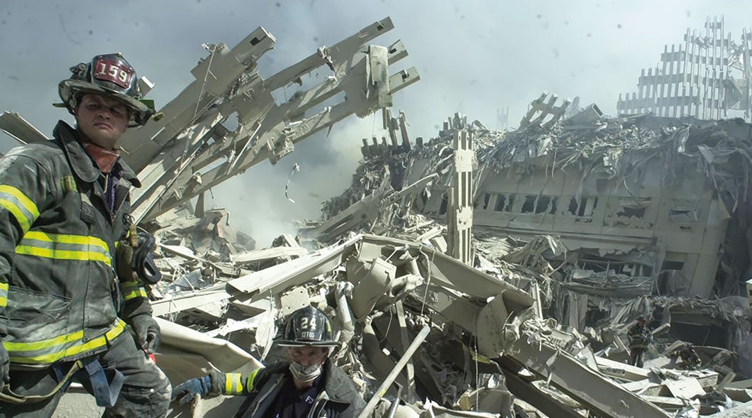 Historical photo of two firefighters amid the rubble and debris at Ground Zero on September 11, 2001
