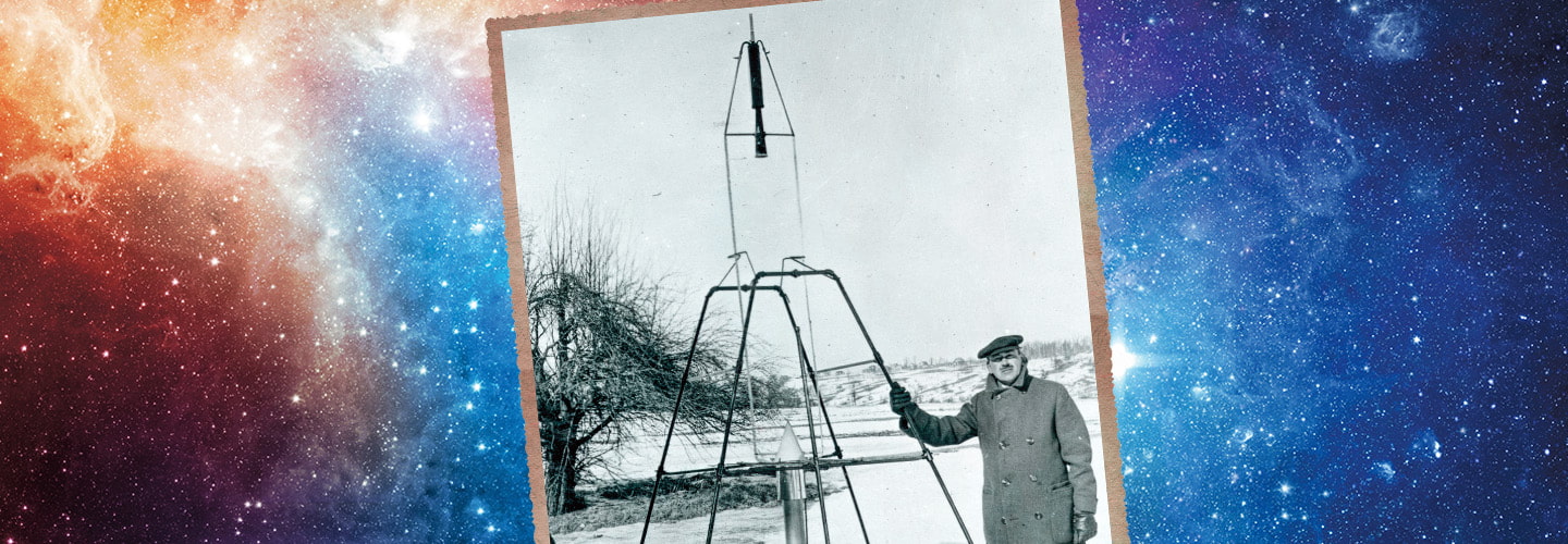 Historical photo of a man who stands beside a tall rocket on a launch frame in a snowy field