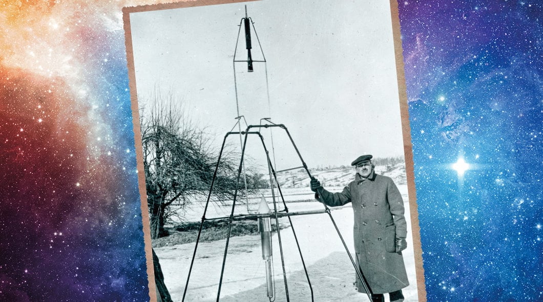Historical photo of a man who stands beside a tall rocket on a launch frame in a snowy field
