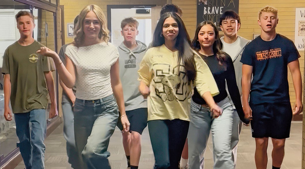 Composite image of 8 students walking side by side down a school hallway toward the camera